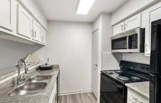 a kitchen with a sink and a stove and a microwave