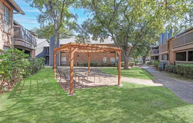 A backyard with a swing set and a wooden pergola.