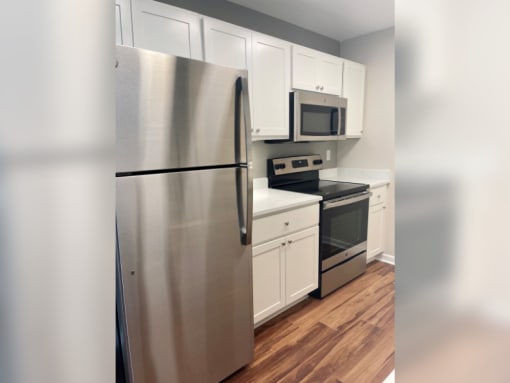 a kitchen with stainless steel appliances and white cabinets