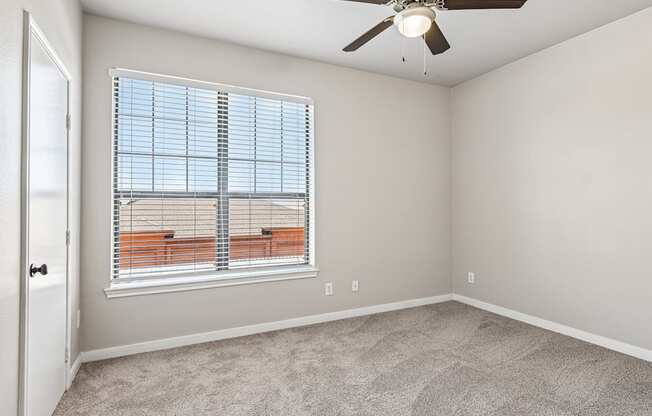 A room with a window and a ceiling fan.