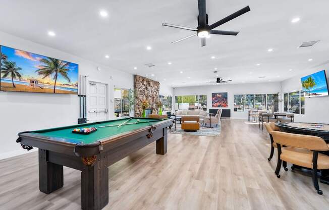 A room with a pool table and a billiard table.