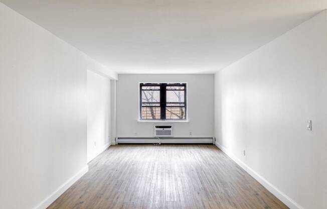 an empty room with white walls and a window