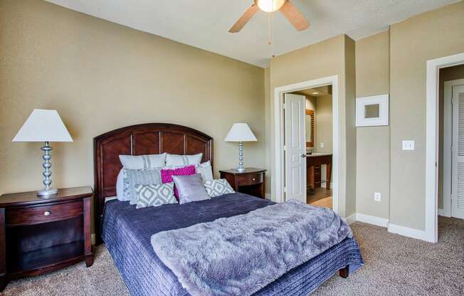 a bedroom with a large bed and a ceiling fan At Metropolitan Apartments in Little Rock, AR