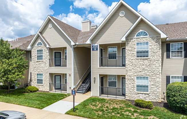 A two-story residential building with a stone facade and a garage door.