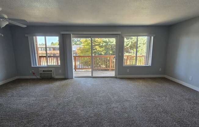 an empty living room with sliding glass doors to a balcony