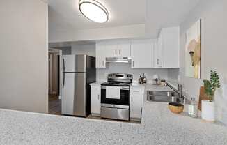 Colton, CA Apartments For Rent - Ardella At Reche Canyon - Renovated Kitchen With Granite Countertops, Stainless Steel Appliances, And White Cabinets.