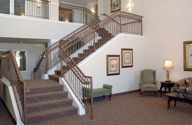 a lobby with a staircase and furniture in it
