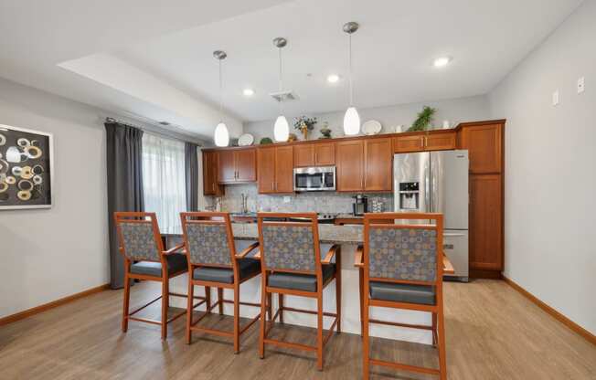 a kitchen with wooden cabinets and a long island with chairs