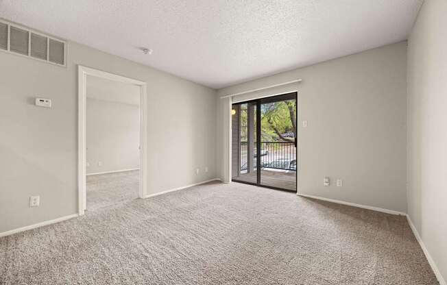 A room with a carpeted floor and a sliding glass door leading outside. at Montecito, Austin, TX, 78741