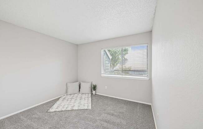 A bedroom with a window and a bed.