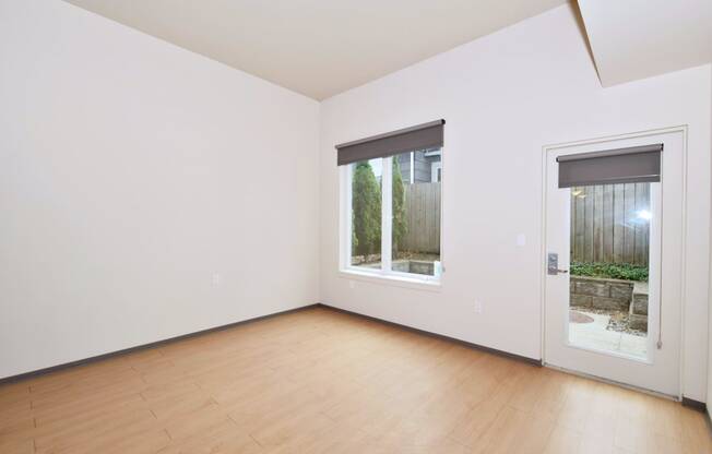 a bedroom with hardwood floors and white walls