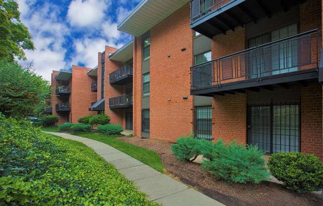 an apartment building with a sidewalk in front of it