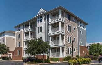 an apartment building with balconies and cars parked in front