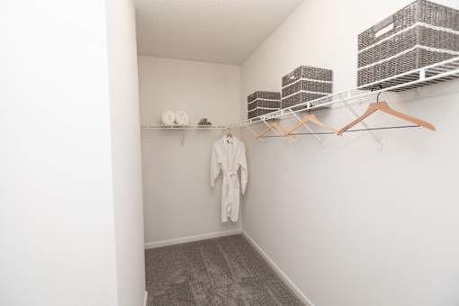 A white room with a hanger and a white robe hanging on the wall.