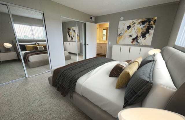 a bedroom with a large bed and a large mirror