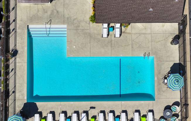 An aerial view of the community pool with lounge chairs & umbrellas