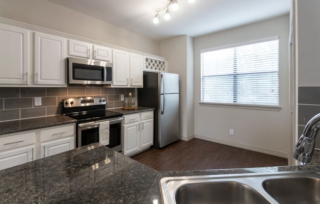 This is a photo of the kitchen of the 1486 square foot 3 bedroom, 3 bath floor plan at The Brownstones Townhome Apartments in Dallas, TX.