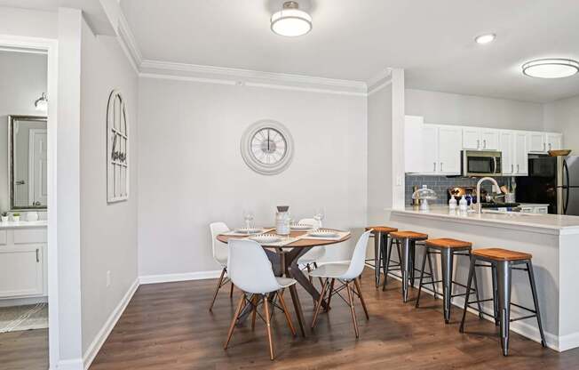 A kitchen with a dining table and chairs.