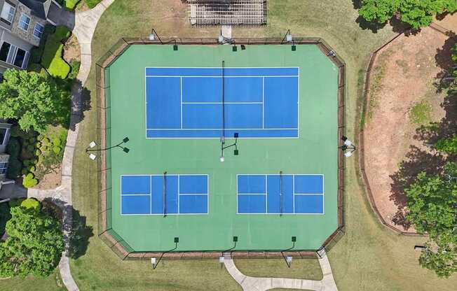 A birds eye view of a tennis court  and pickleball courts with a gazebo next to them
