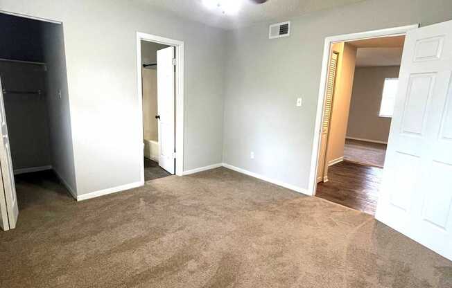 A room with a ceiling fan and carpeted floor.