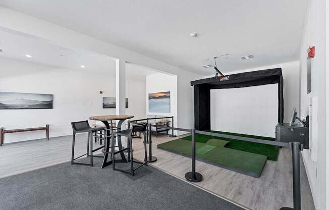A room with a table and chairs and a large screen.