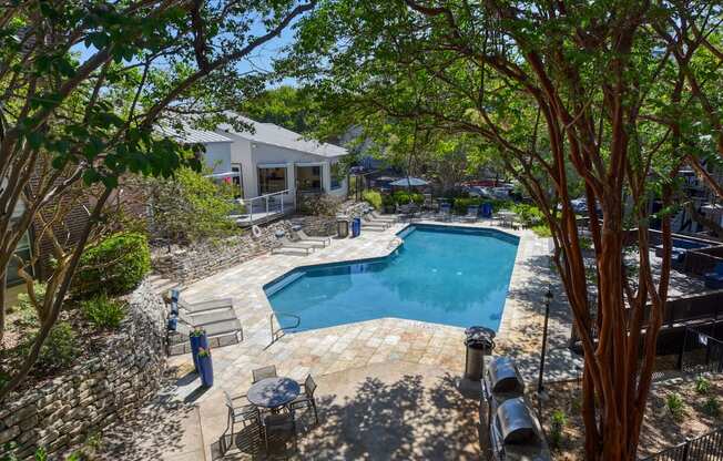 a backyard with a pool and patio with a house in the background
