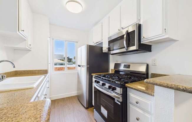 A kitchen with a black stove and white cabinets.