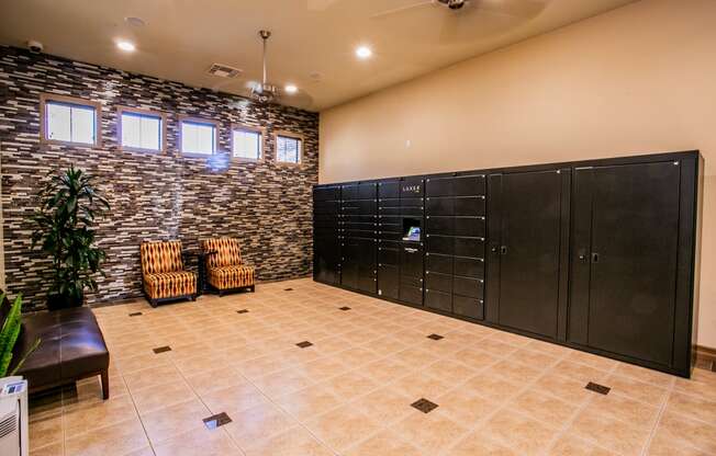 a large locker room with black lockers and chairs and a plant