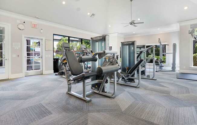 A gym with a row of treadmills and a weight machine.