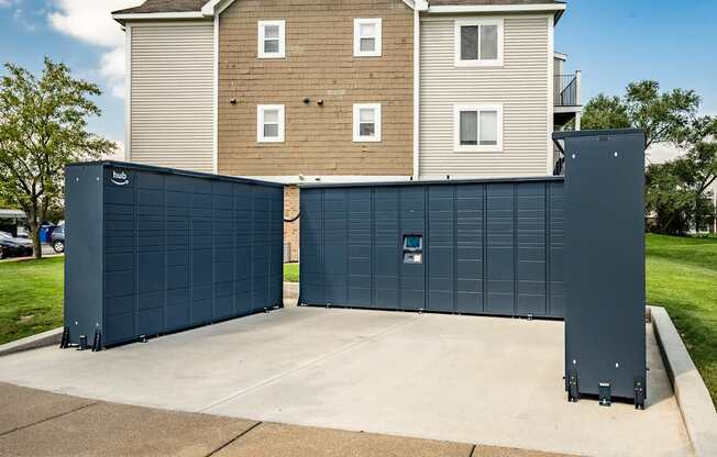 A large blue garage door in front of a two-story apartment building