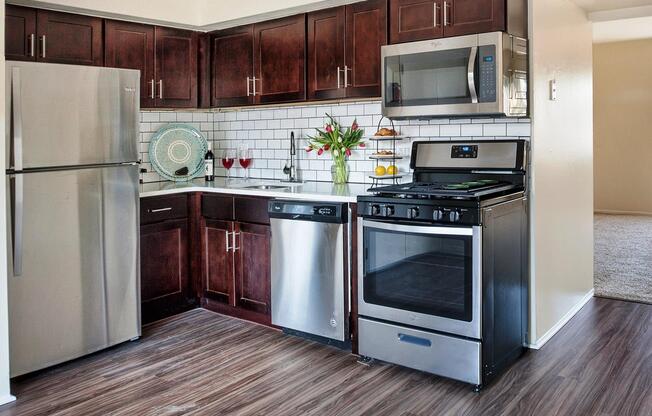 Renovated open-concept dining and kitchen areas with stainless steel appliances at Franklin Commons apartments for rent