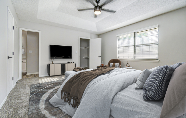 Furnished townhome platinum bedroom interior with wall-mounted TV at The Arbor in Blue Springs, MO