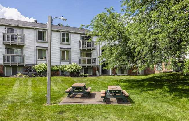 A grassy area with a picnic table in front of a building