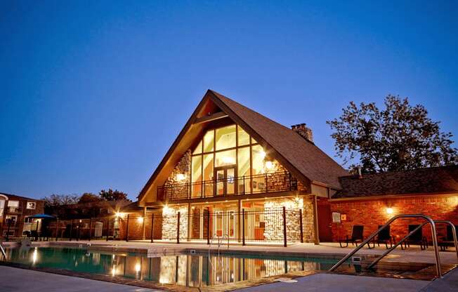 a  apartment clubhouse with a swimming pool at night