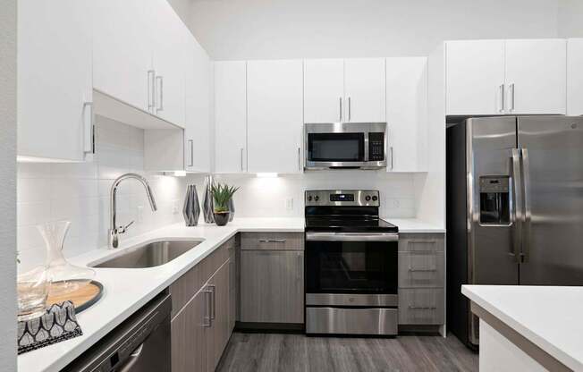 A modern kitchen with stainless steel appliances and white cabinets.
