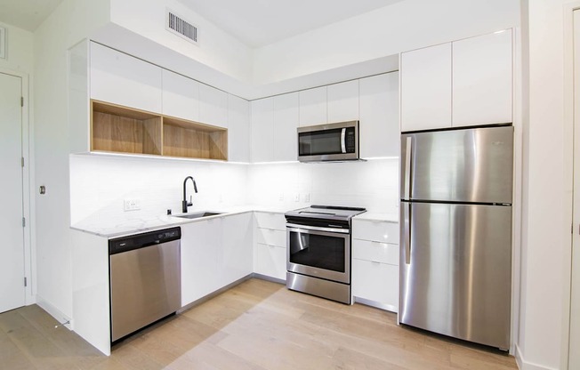 A kitchen with white cabinets and stainless steel appliances.at The Dillon, California, 90026