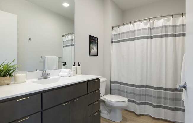 a bathroom with a toilet sink and shower in a 555 waverly unit