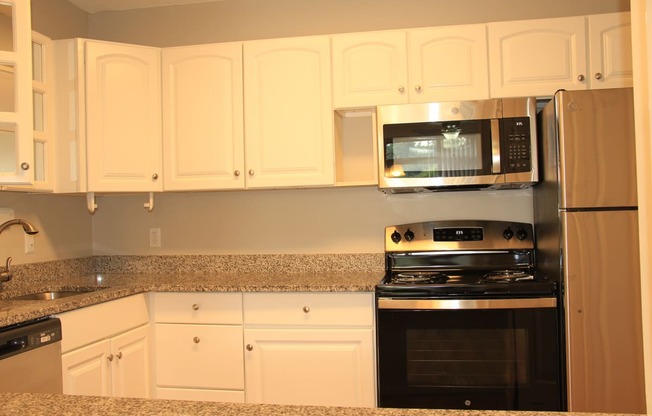 a kitchen with white cabinets and a stove and a microwaveat Renew Worcester, Worcester, MA, 01602