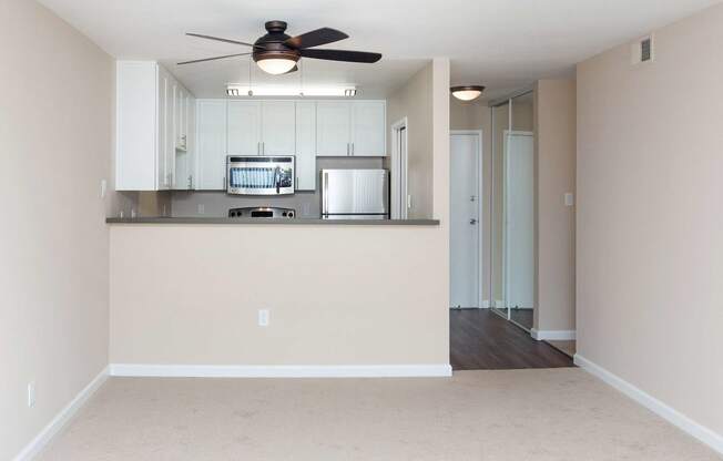 a bedroom with a large window and a ceiling fan