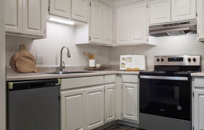 A kitchen with white cabinets and a black oven.