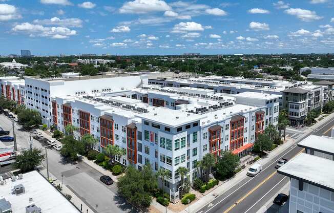 A large multi-story building with a parking lot in front.