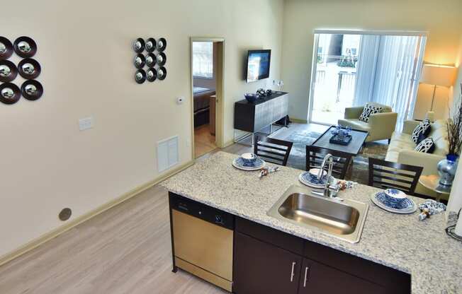 a kitchen with a granite counter top and a living room with a couch and tv