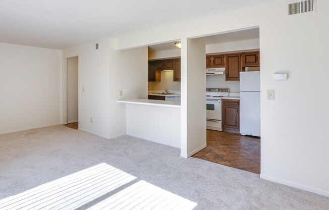 the living room and kitchen of an empty apartment