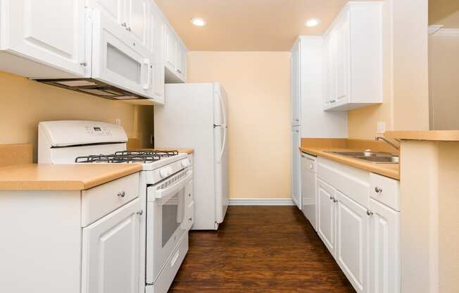 a kitchen with white cabinets and white appliances