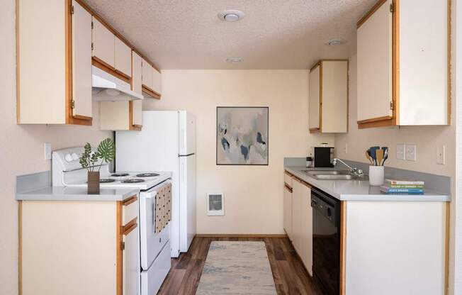 A kitchen with white appliances and wooden cabinets.