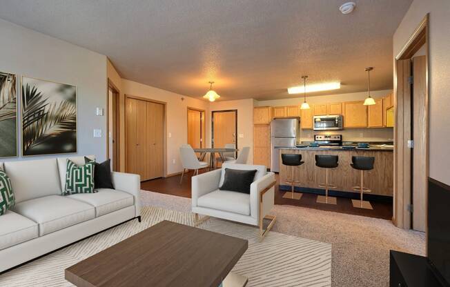 a living room and kitchen with a couch and a table. Fargo, ND East Bridge Apartments