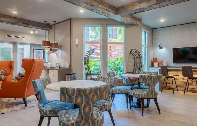 A living room with a round table surrounded by chairs.