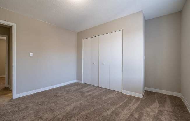 A room with carpeted floor and a white door.