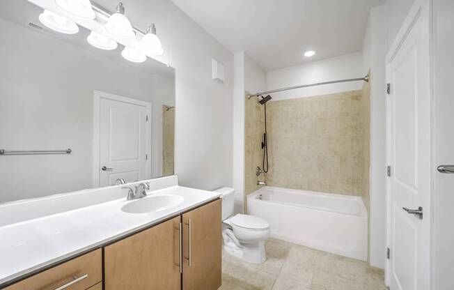 A bathroom with a white sink, toilet, and bathtub.