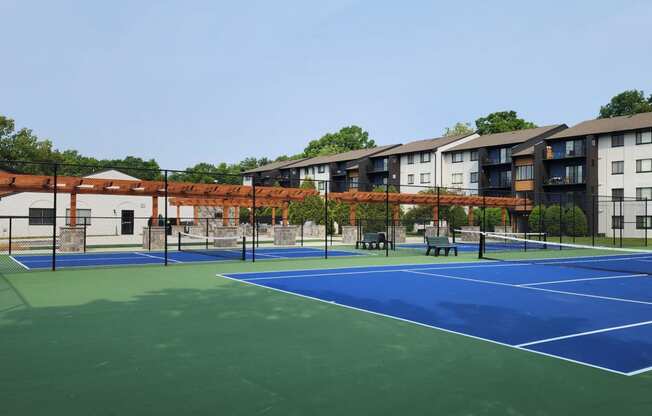 Tennis and pickle ball courts with apartments in the background at Woods of Fairfax.